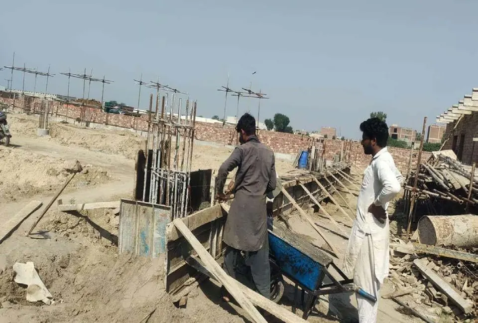 Site workers fixing formwork for a reinforced concrete column base