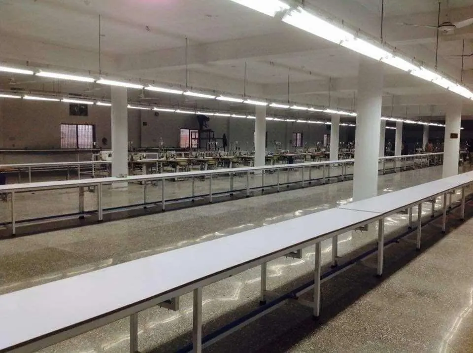 Completed production hall with long work tables under bright lighting